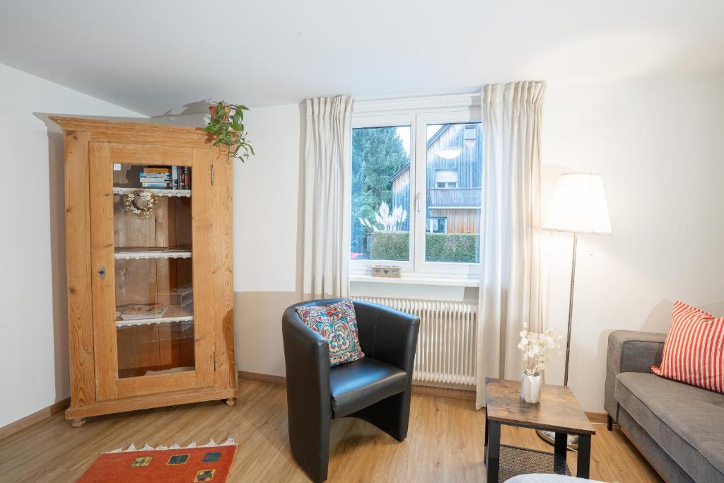 a living room with a chair and a window at Chalet zum See in Bregenz