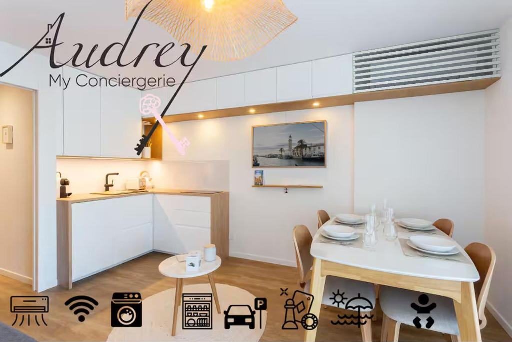 a dining room with a table and a kitchen at La Loggia du Triton - Superbe T2 avec parking in Le Grau-du-Roi