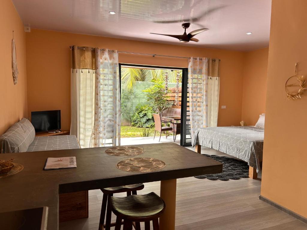 a living room with a bed and a dining room table at PUNA Lodge in Atiue