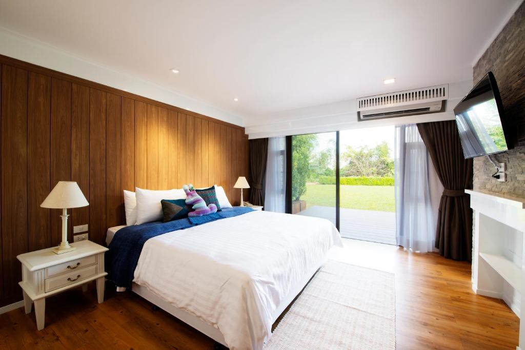 a bedroom with a large bed and a tv at DoiTung Lodge in Ban Rai