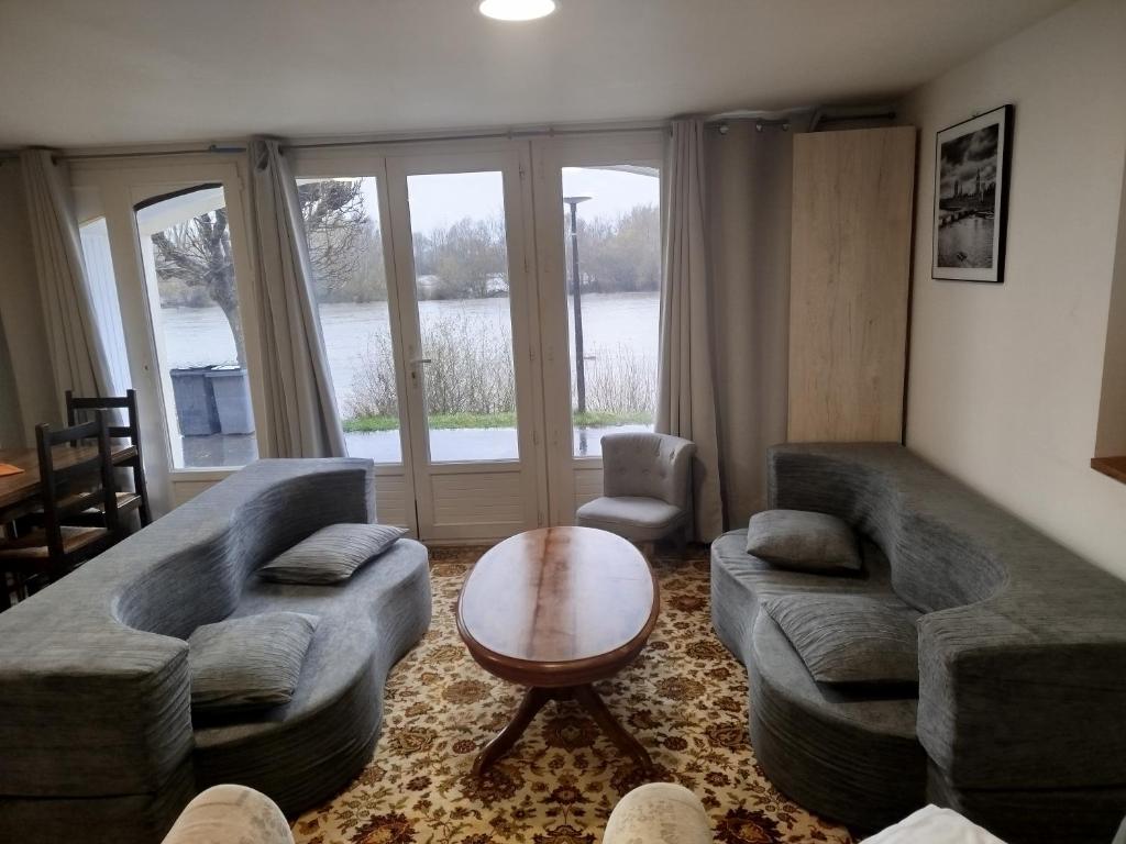a living room with a couch and a table and chairs at Locations de la centrale de Belleville in Neuvy-sur-Loire