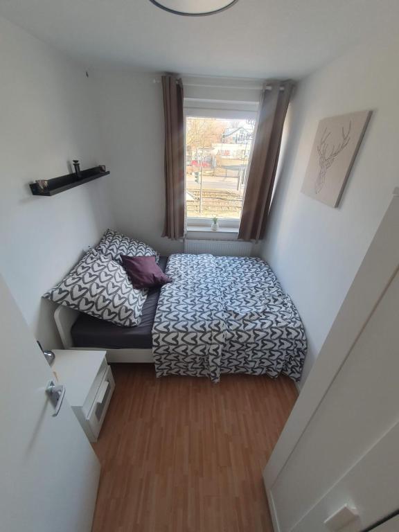 a small bedroom with a bed and a window at Angenehmes privatzimmer in Cologne