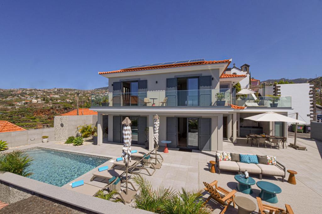 a villa with a swimming pool and a house at Villa Macedo in Ponta do Sol