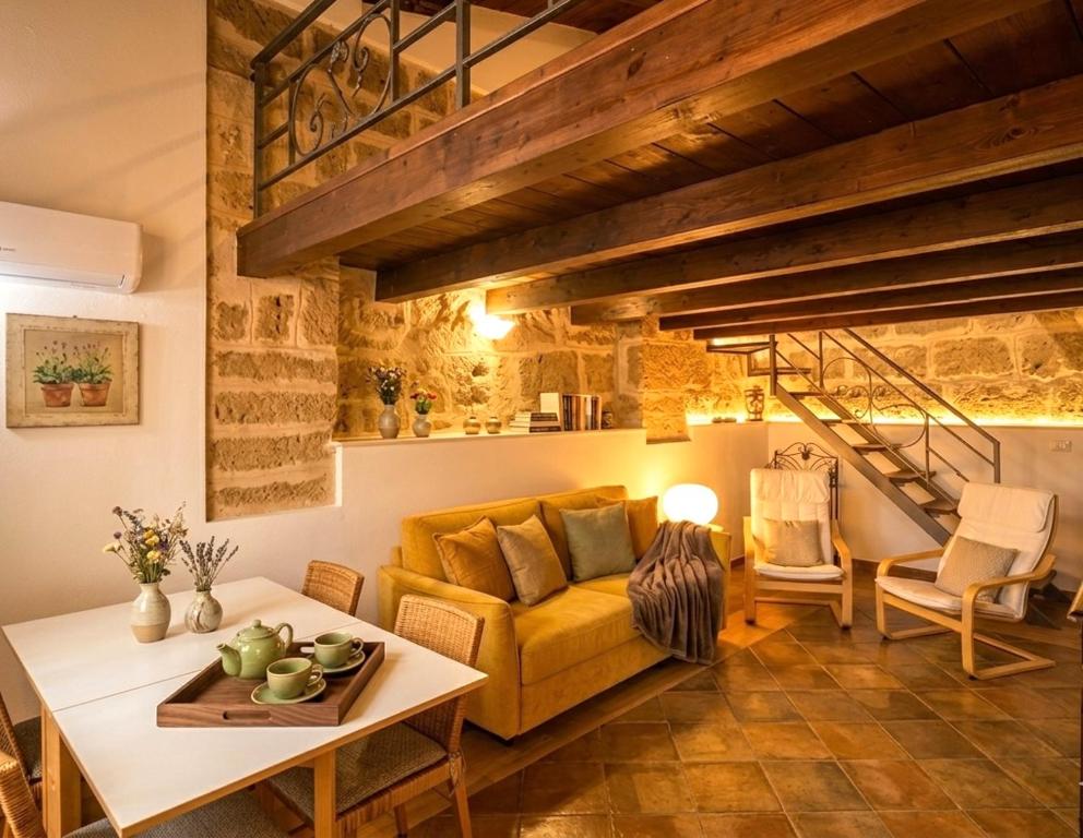 a living room with a yellow couch and a table at Emerald apartment in Alghero Historic Center in Alghero