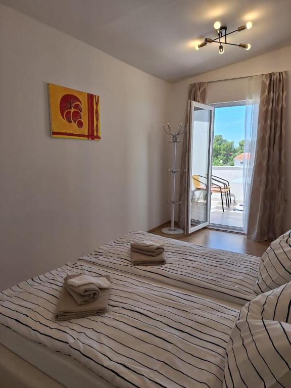 a bedroom with a large bed with two towels on it at Apartmani Drago in Vir