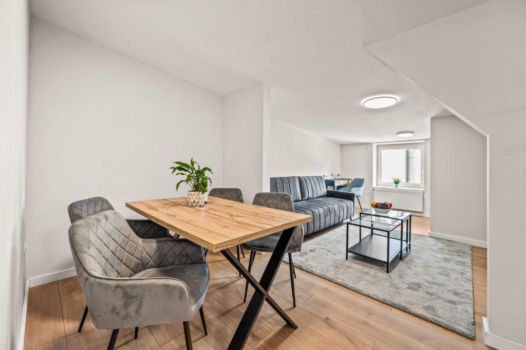 a living room with a wooden table and chairs at Platinum Elite Residence in Rybnik