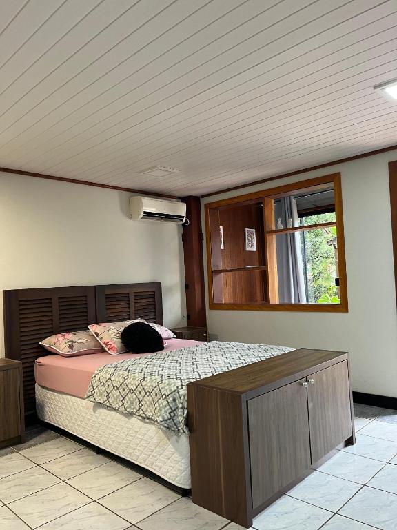 a bedroom with a bed and a window at Suite Familia A1 in Pomerode