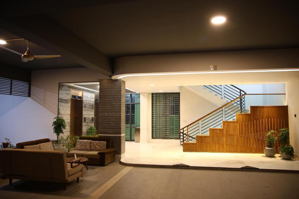 a living room with a couch and a staircase at Pearl Serenity in Sholāshahar