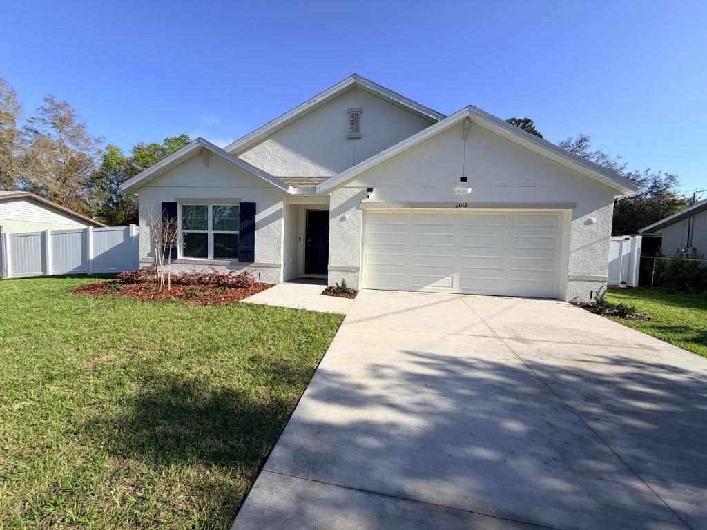 a white house with a garage at Paradise in the Springs in Citrus Springs