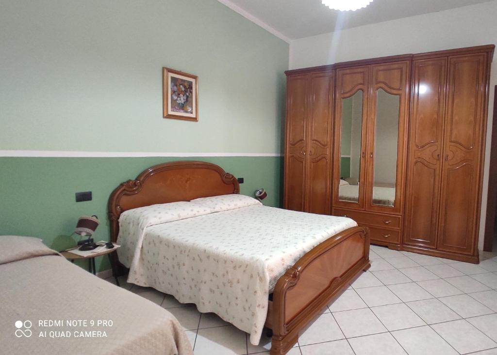 a bedroom with a bed and a wooden cabinet at Casa Cesa in Selargius