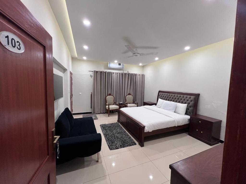 a hotel room with a bed and a chair at Bridge Residency in Islamabad
