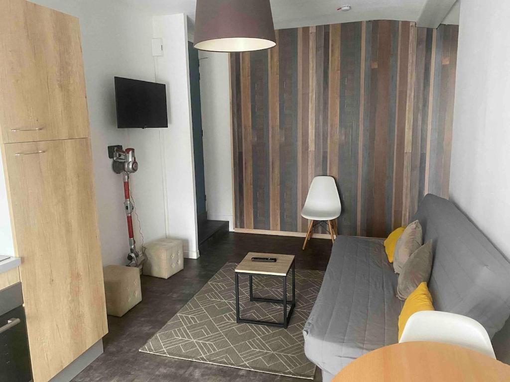 a living room with a couch and a table at T2 cyclamen independent in Cholet