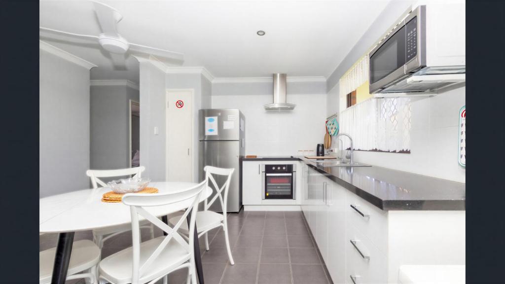 a kitchen with a table and a counter top at Ocean Beach Chalet 18 in Jurien Bay