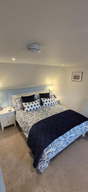 a bedroom with a bed with a black and white comforter at Wayside Cottage Gairloch Room Accommodation in Gairloch