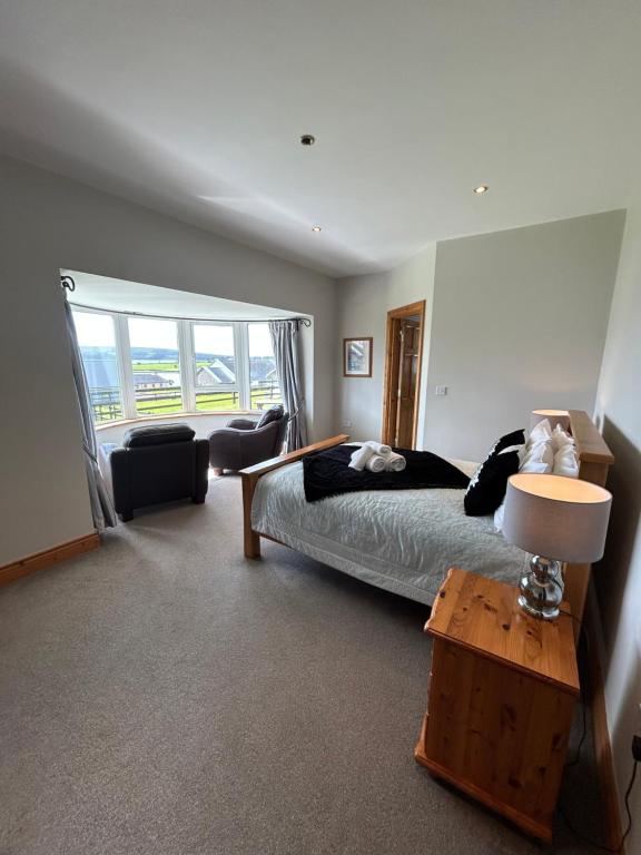 a bedroom with a bed and a large window at Dingle Mist in Dingle