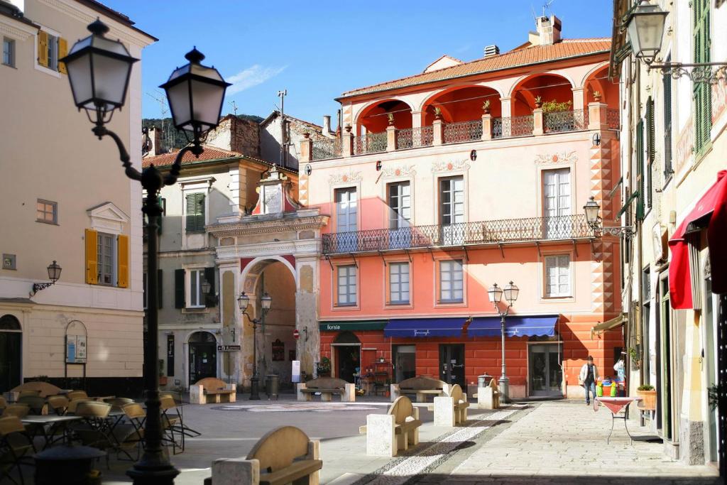 une rue urbaine avec des bâtiments et un éclairage de rue dans l'établissement Palazzo Aycardi, à Finale Ligure