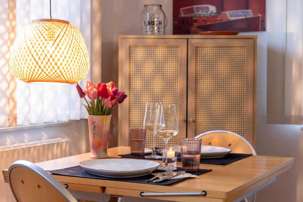 a dining room table with plates and flowers and a lamp at Vacation, also with a dog, in Stade! in Stade