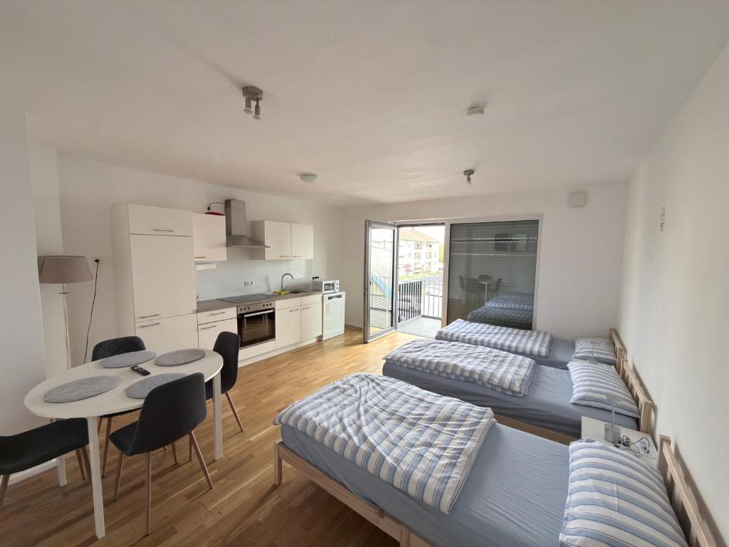 a room with two beds and a table and a kitchen at LuxApart2Cologne in Kerpen