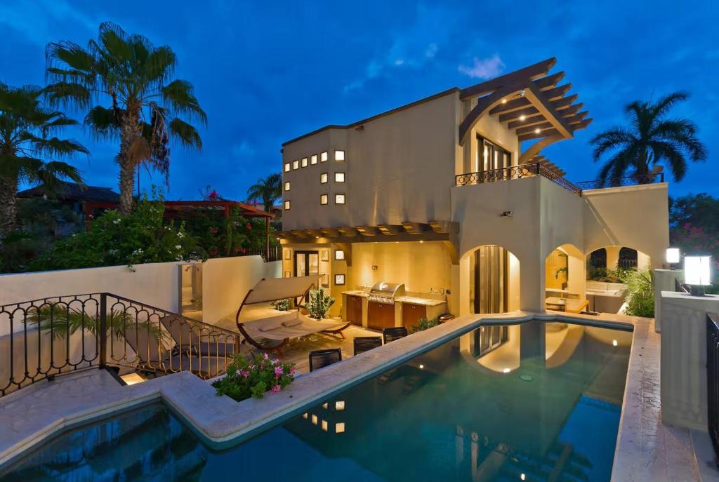 a large house with a swimming pool in front of it at Marbella Lane Coastal Elegance Villa with Pool in Cabo San Lucas