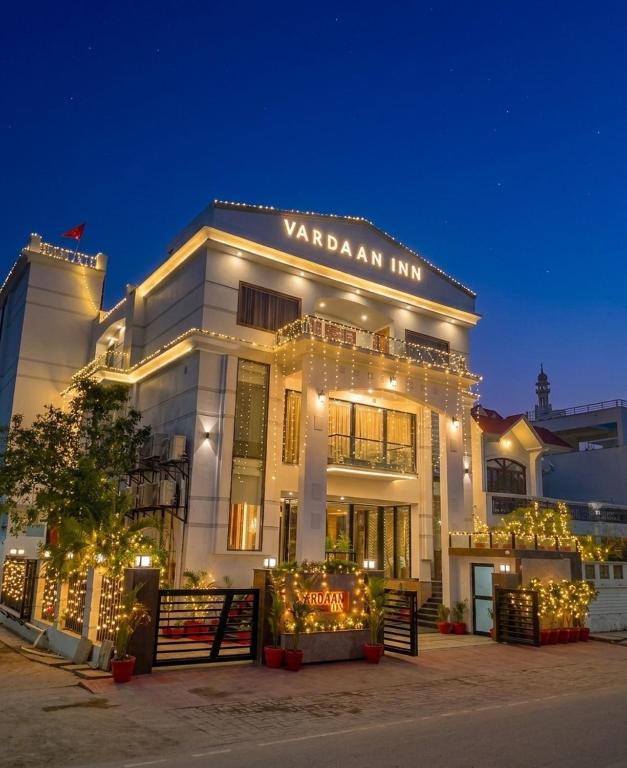 a white building with christmas lights in front of it at Hotel Vardaan Inn in Lucknow