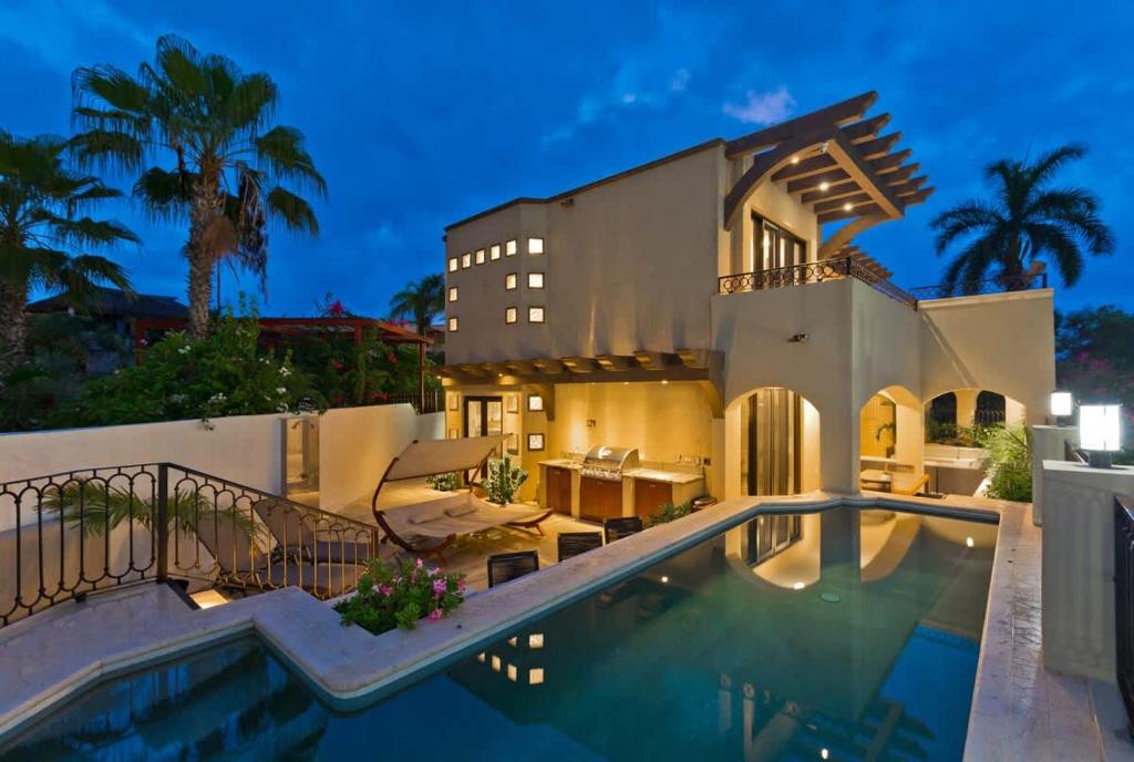 a large house with a swimming pool in front of it at Marbella lane - Stylish Private Villa OceanViews in Cabo San Lucas