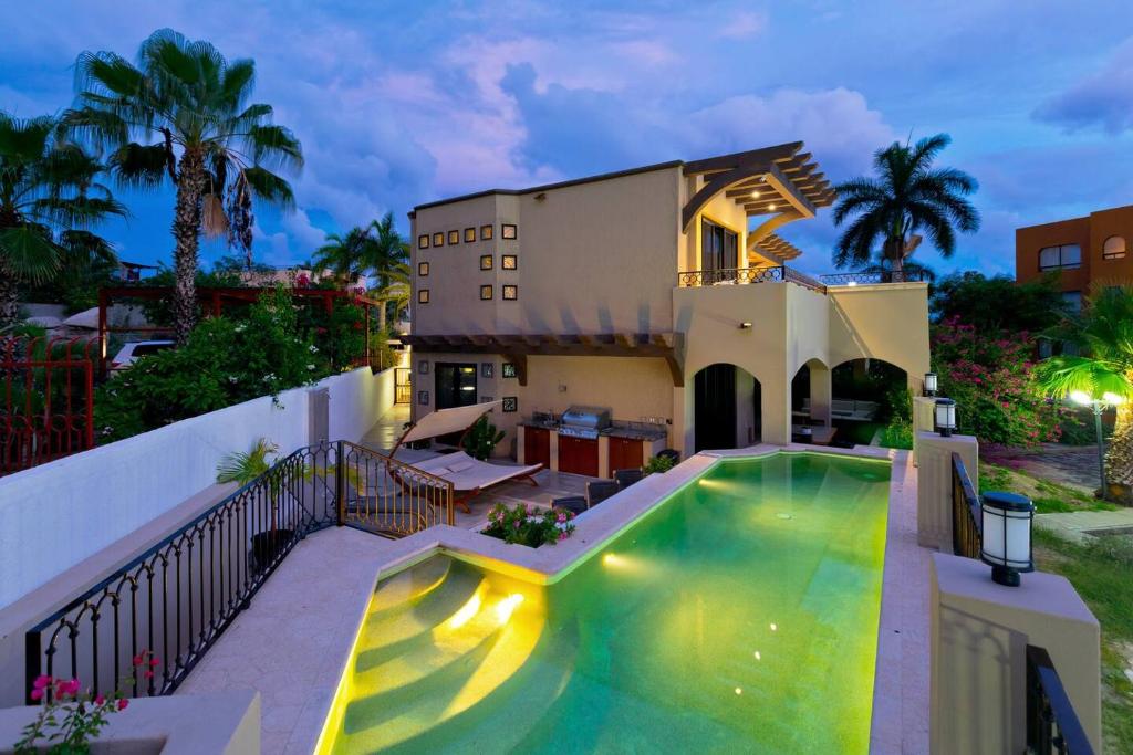 a house with a swimming pool in front of a house at Marbella lane - Chic Casa with Amazing OceanViews in Cabo San Lucas
