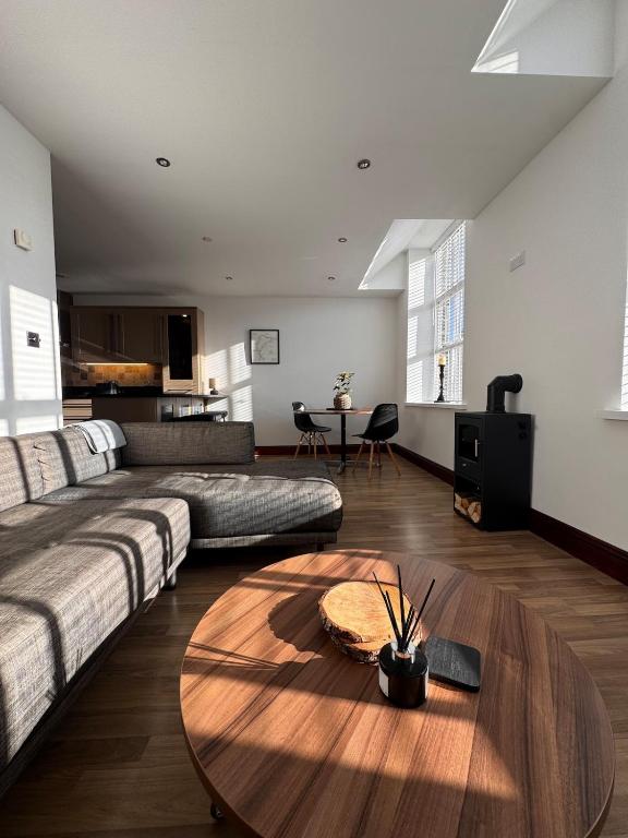 a living room with a couch and a table at Hollins Mill Apartment in Sowerby Bridge