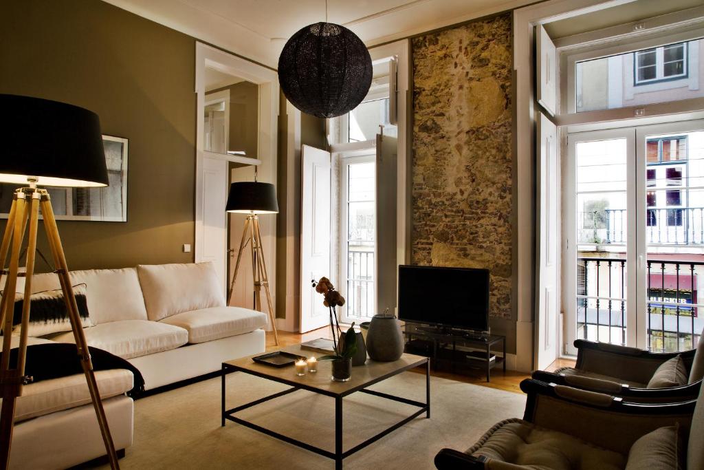 ein Wohnzimmer mit einem Sofa und einem TV in der Unterkunft Lisbon Five Stars Apartments São Paulo 55 in Lissabon