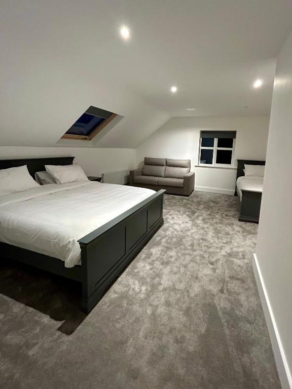 a bedroom with a large bed and a couch at Modern house Boyle in Boyle
