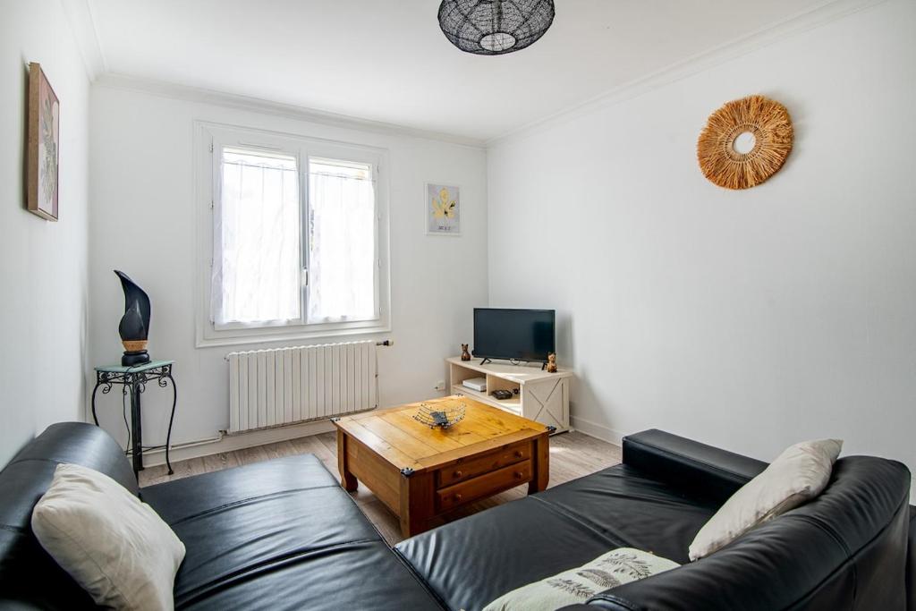 a living room with a couch and a coffee table at Maison Mylan, simple and practical! in Cholet