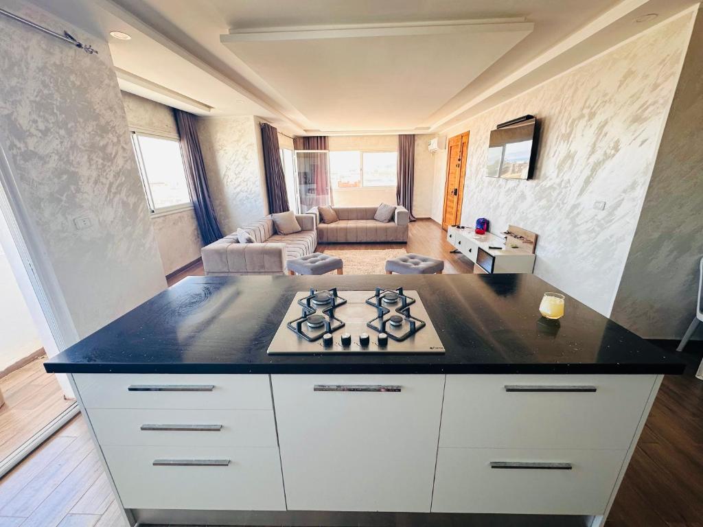 a kitchen with a stove and a living room at Bizerta Méditerranée in Bizerte