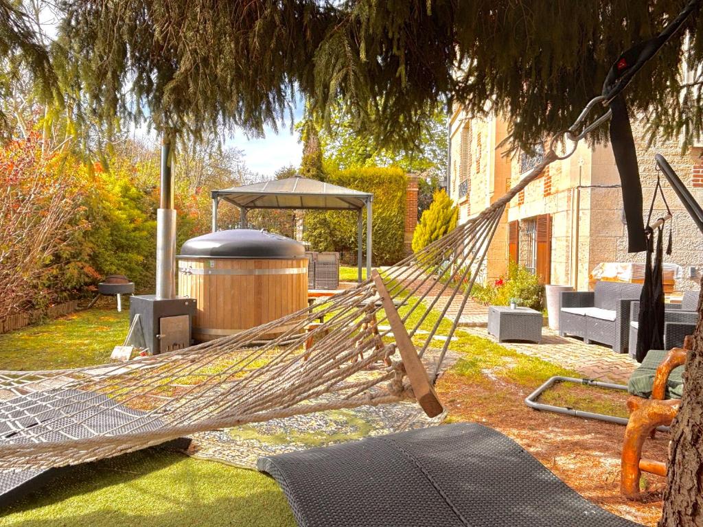 a hammock in a garden with a gazebo at Gite L'Instant Champenois in Bréviandes