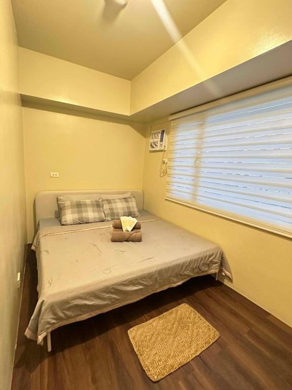 a small bedroom with a bed with a window at Ilo2stayAirbnb 1BR 334 in Molo