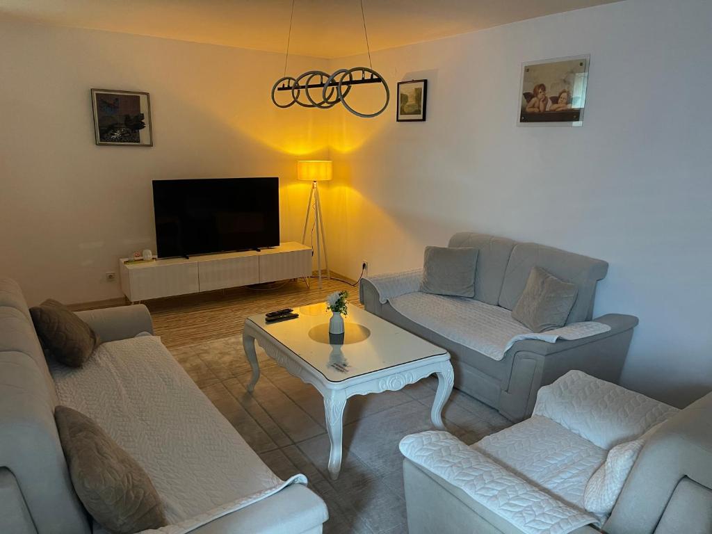 a living room with two couches and a tv at Apartman Deluxe in Novi Travnik