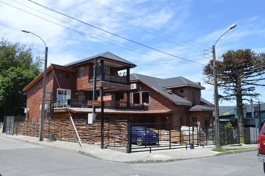 a wooden house on the side of a street at Hotel boutique Refugio de Navegantes in Dalcahue