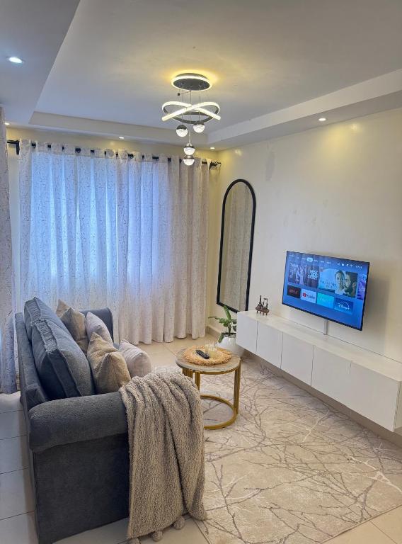 a living room with a couch and a flat screen tv at SerenityLoft by Gloria in Thika