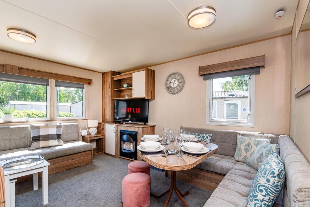 a living room with a couch and a table at Coastal Caravan at Seton Sands -Near Edinburgh in Port Seton