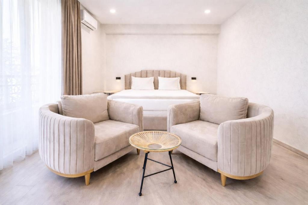 a bedroom with a bed and a couch and a table at Royal Renaissance Boutique by IGIT in Yerevan