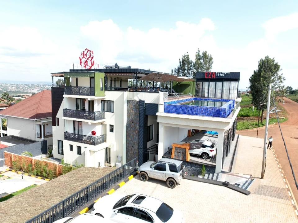 a white building with cars parked in front of it at Eza Hotel in Kigali