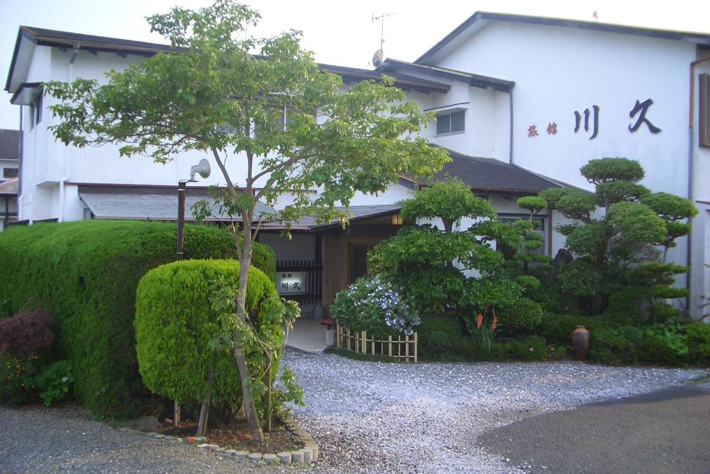 a small tree in front of a building at Family Ryokan Kawakyu with Showa Retro in Ibusuki