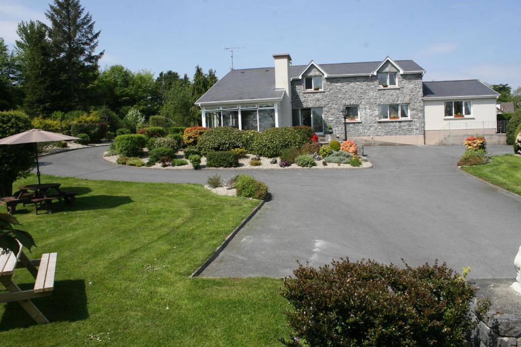 a house with a driveway in front of it at Carrowntober House B & B in Oughterard