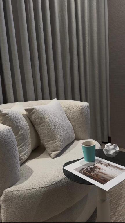 ein Tablett auf einem Sofa, eine Tasse auf einem Tisch in der Unterkunft Highest End Hotel in Al-'Ula