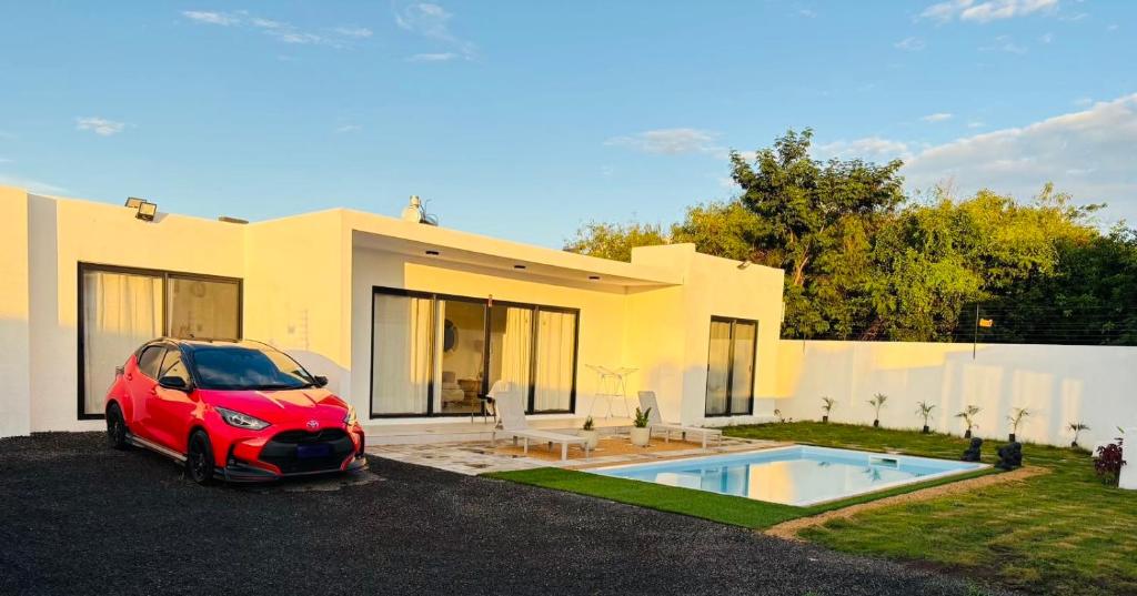 a red car parked in front of a house at Villa Le Caprice in Grand-Baie
