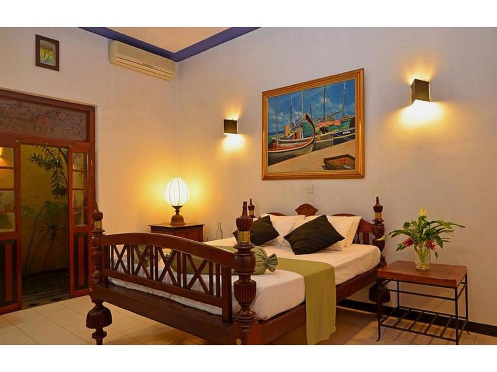 a bedroom with a bed and a painting on the wall at Villa Capers in Colombo