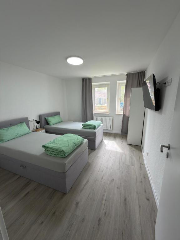 a room with two beds and a tv in it at Ruheblick Apartment Essen in Essen