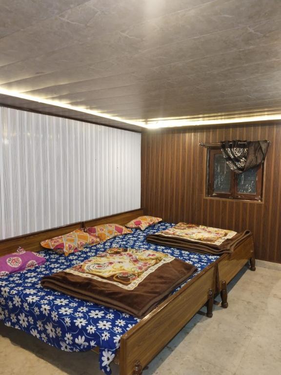 two twin beds in a bedroom with wooden walls at Himalayan siddhi yog aashram in Badrinath