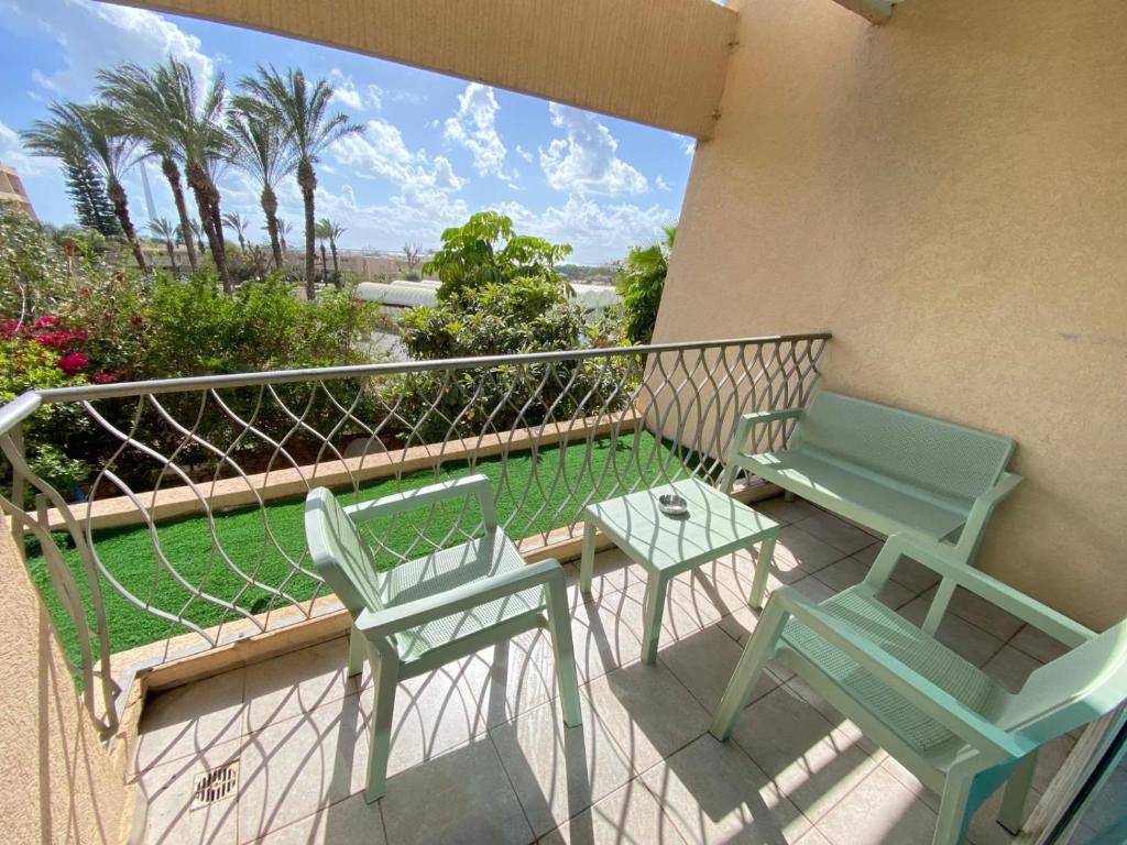 two chairs and a table on a balcony at Pure Bliss Caesarea - אושר טהור בקיסריה in Caesarea