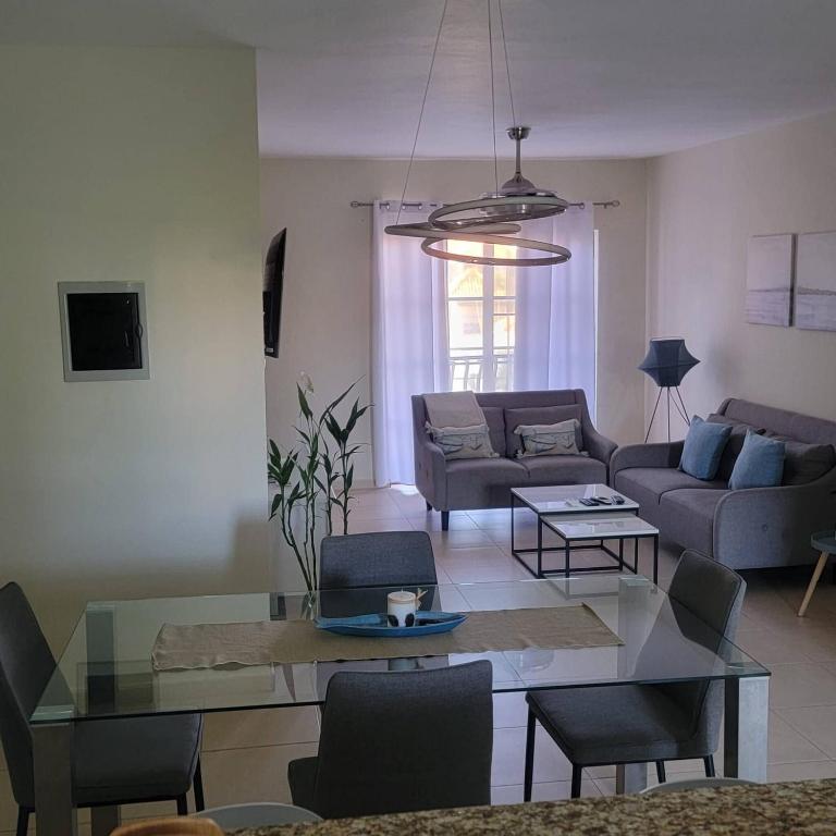 a living room with a glass table and a couch at 2BR Condo with Pool, Walk to Beach, Bvaro in Punta Cana