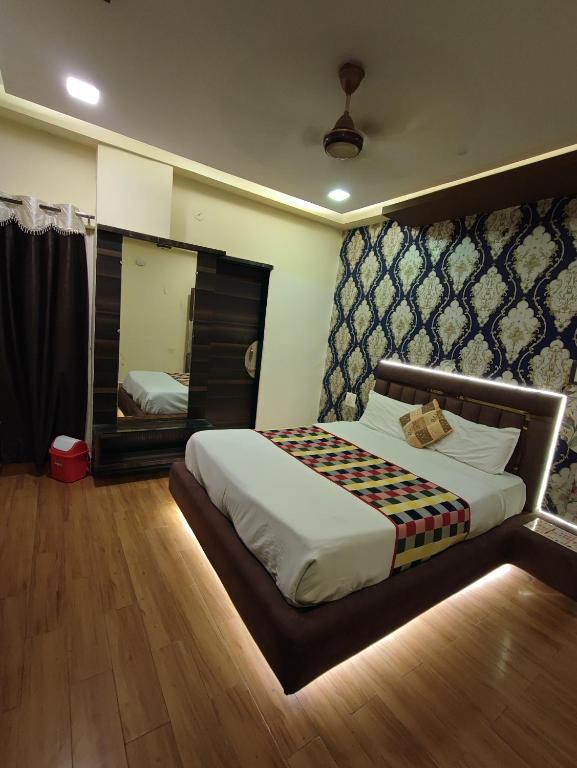 a bedroom with a large bed and a mirror at hotel shree shyam palace in Ujjain
