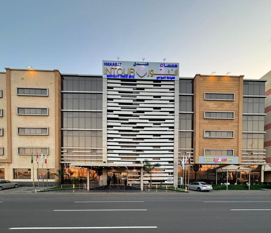 a large building with a sign on top of it at Hmaasat Intour Hotel فندق همسات انتور in Jazan